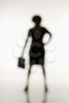 Royalty Free Photo of a Soft Focus Silhouette of a Businesswoman Standing Holding a Briefcase