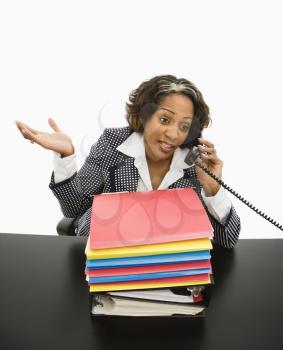 Royalty Free Photo of a Businesswoman Sitting at a Desk Talking on a Telephone