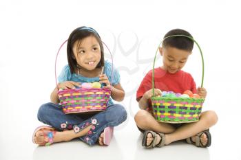 Royalty Free Photo of a Girl and Boy Sitting on the Floor Holding Easter Baskets Full of Eggs