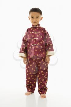 Royalty Free Photo of a Boy Standing Against a White Background in Traditional  Attire