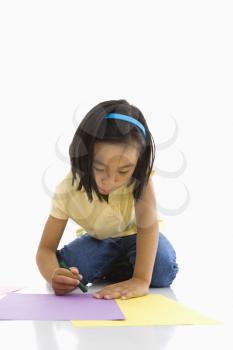 Royalty Free Photo of a Girl Sitting on the Floor Coloring on a Piece of Paper