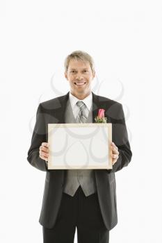 Royalty Free Photo of a Groom Holding a Blank White Sign