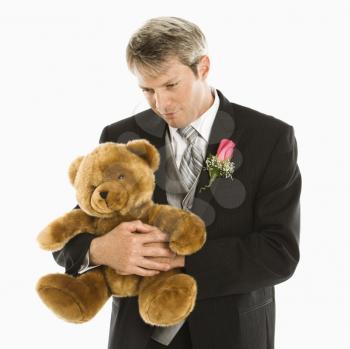 Royalty Free Photo of a Groom Hugging a Teddy Bear