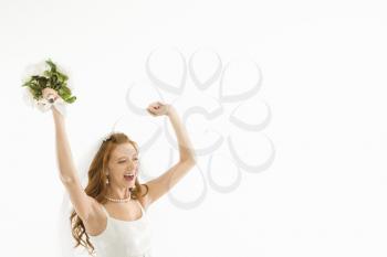 Royalty Free Photo of a Bride Holding a Bouquet and Raising Her Arms
