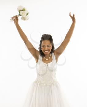 Royalty Free Photo of a Bride Holding A Bouquet With Her Arms Raised
