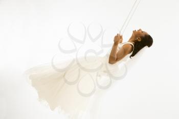 Royalty Free Photo of a Bride Swinging on a Swing