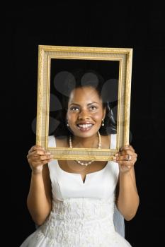 Royalty Free Photo of a Bride Holding a Frame Around Her Face