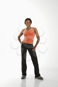 Royalty Free Photo of a Young Woman in Athletic Wear Smiling With Hands on Hips
