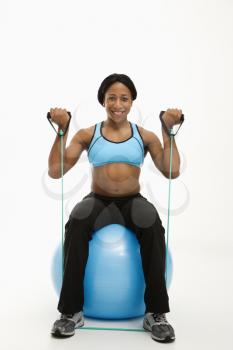 Royalty Free Photo of a Woman Working Out With an Exercise Ball Using a Resistance Tube