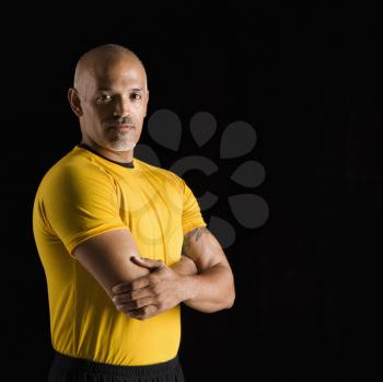Royalty Free Photo of a Man Wearing an Exercise Shirt With Arms Crossed
