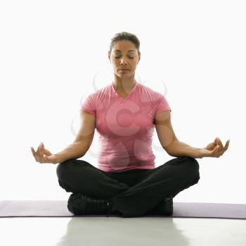 Royalty Free Photo of a Woman Sitting in a Lotus Position Practicing Yoga on an Exercise Mat With Eyes Closed