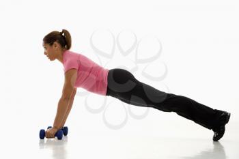 Royalty Free Photo of a Woman Wearing a Pink Exercise Shirt Doing Push-ups While Holding Dumbbells
