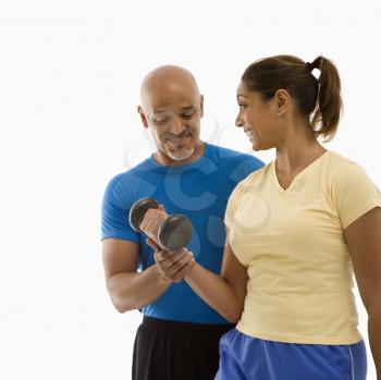 Royalty Free Photo of a Smiling Man Assisting a Woman With Dumbbells