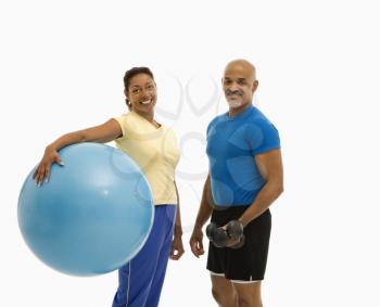 Royalty Free Photo of a Man Standing Next to a Woman Holding an Exercise Ball