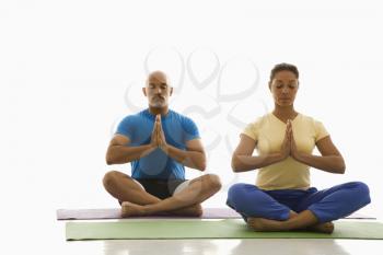 Royalty Free Photo of a Man and Woman Sitting in Namaste Position on Exercise Mats
