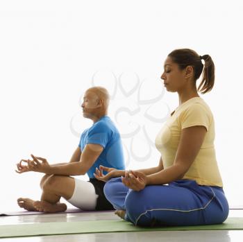 Royalty Free Photo of a Woman and Man Sitting on Exercise Mats in the Lotus Position