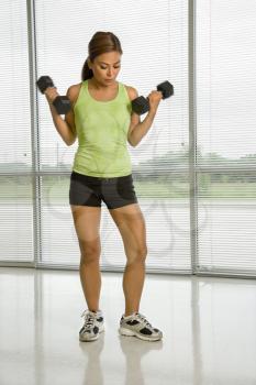 Royalty Free Photo of an Asian Woman Standing Lifting Dumbbells