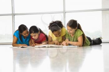 Royalty Free Photo of Girls of Sitting Together on the Floor With Schoolwork