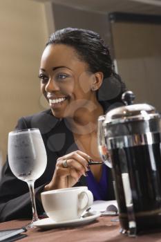 Royalty Free Photo of a Businesswoman Smiling and Sitting at a Table in a Restaurant