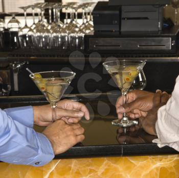 Royalty Free Photo of Men Holding Martinis at a Bar