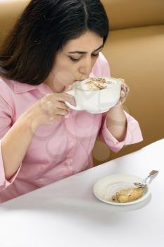 Royalty Free Photo of a Woman Drinking a Cappuccino