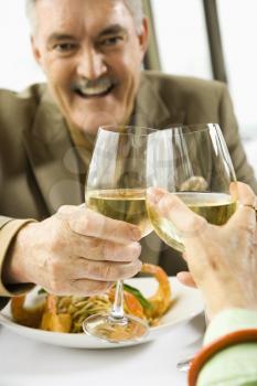 Royalty Free Photo of a Couple Toasting With White Wine in a Restaurant