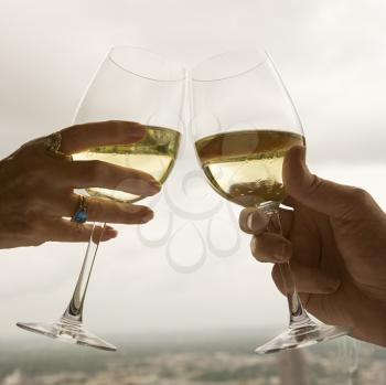 Royalty Free Photo of a Close-up of a Mature Couple's Hands Toasting Wine