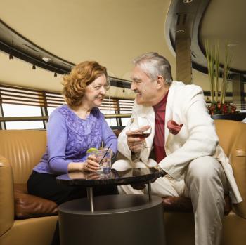 Royalty Free Photo of a Couple Sitting in a Bar Lounge Having Drinks and Talking