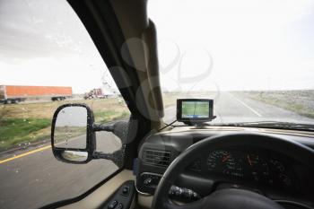 Royalty Free Photo of a Vehicle Dashboard With GPS and View Through Windshield of a Highway Ahead