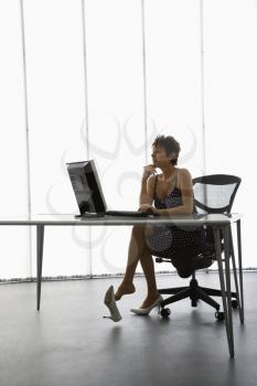 Royalty Free Photo of a Businesswoman Sitting at a Desk With Computer in Office