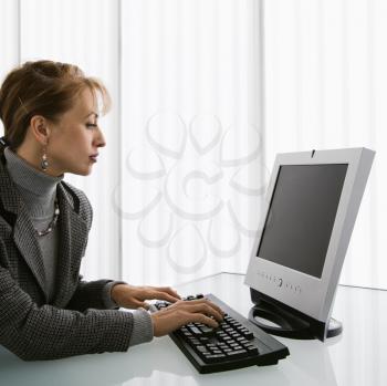 Caucasian woman typing on computer keyboard.