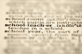 Selective focus of dictionary definition for the word schoolteacher.