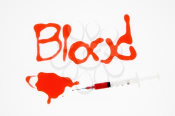 Royalty Free Photo of a Hypodermic Needle With Red Liquid Spelling Blood