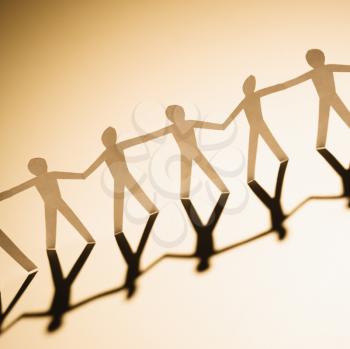 Royalty Free Photo of Cutout Paper Men Standing Holding Hands