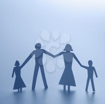 Royalty Free Photo of a Paper Cutout Family of Four Standing Holding Hands