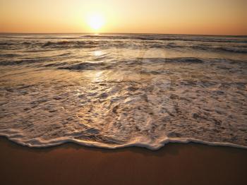 Royalty Free Photo of Waves Lapping on a Beach at Sunset