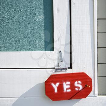 Royalty Free Photo of Wooden Door on a Building With a Sign Reading Yes