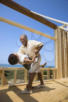 Royalty Free Photo of a Couple Dancing in a New Home Construction at Beach