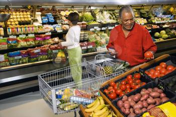 Middle aged African American man and woman in grocery store shopping for produce.