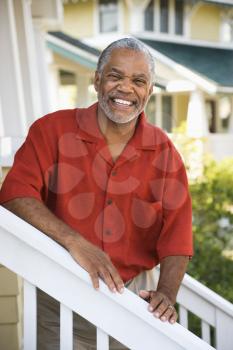 Royalty Free Photo of a Middle-aged Man Smiling and Leaning on a Stairway Railing
