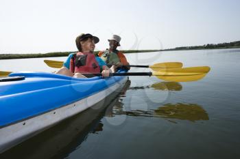 Royalty Free Photo of an African American Couple Sitting in a Kayak on a Lake Smiling and Laughing