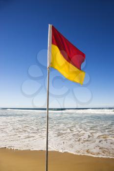 Royalty Free Photo of a Red and Yellow Flag on Beach in Surfers Paradise, Australia