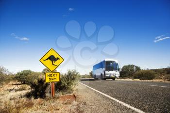 Royalty Free Photo of a Bus on Two Lane Asphalt Road in Rural Australia With a Kangaroo Crossing Sign