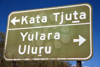 Royalty Free Photo of a Road Sign With a Direction to Kata Tjuta and Yulara Uluru in Uluru Kata Tjuta National Park, Australia