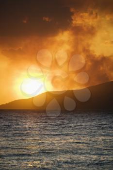 Royalty Free Photo of a Sun Setting Over the Island With the Ocean on Maui, Hawaii