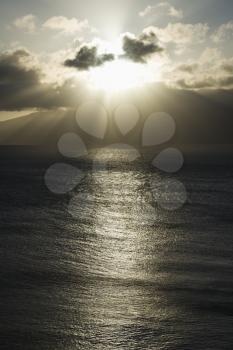 Royalty Free Photo of a Pacific Ocean and Island with Sun Streaming Through Clouds