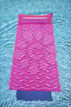 Royalty Free Photo of a Pink Lounge Float in an Empty Swimming Pool