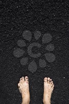 Royalty Free Photo of a Man's Barefeet in Black Sand in Maui, Hawaii