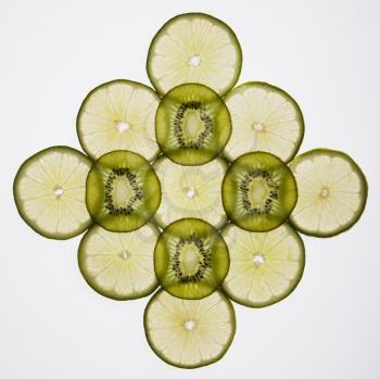 Lime and kiwi fruit slices arranged on white background.