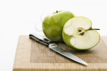 Royalty Free Photo of Green Apples and a Knife on a Cutting Board